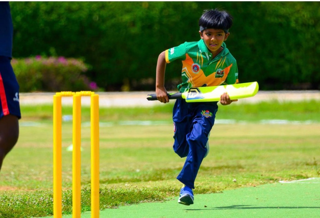 Young batter sprinting with yellow bat