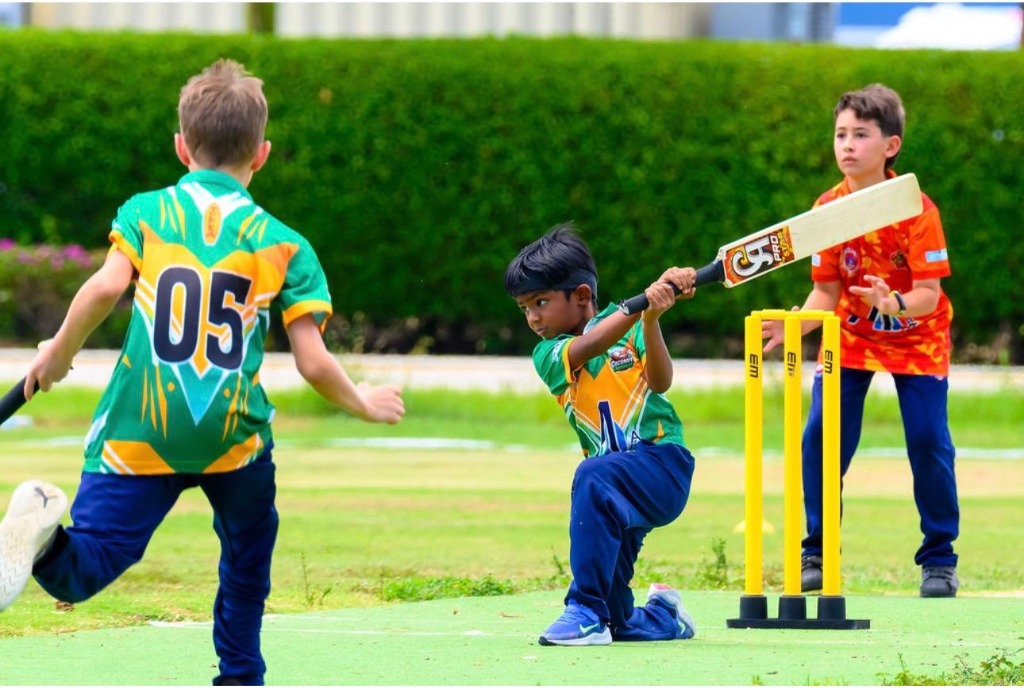 Young batsman executing cut shot with yellow stumps