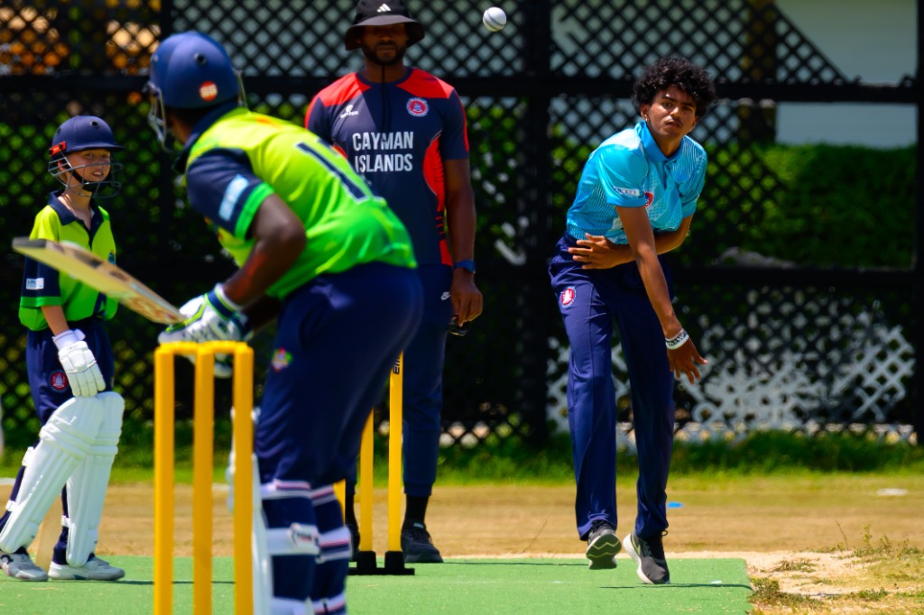 Bowler in mid-air ball release toward batsman